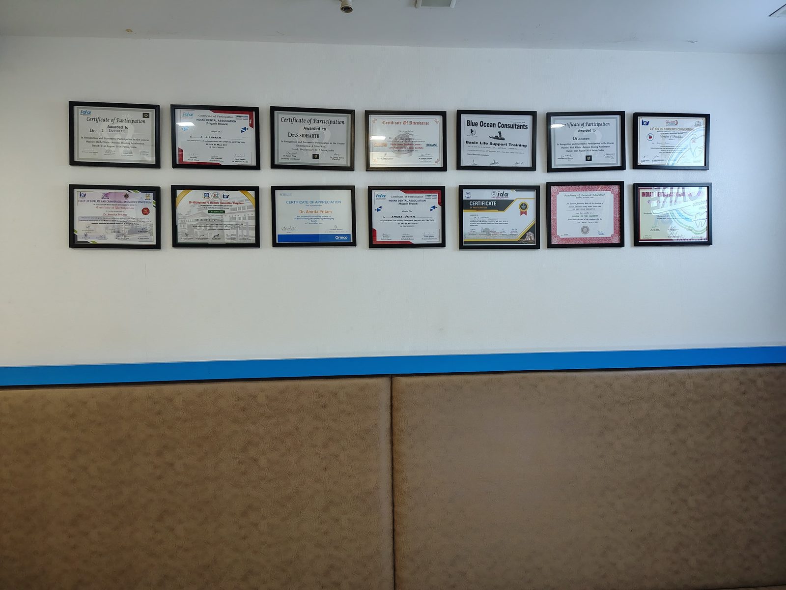 Wall of certifications and continuing education awards displayed at Oro Care & Orthodontic Centre